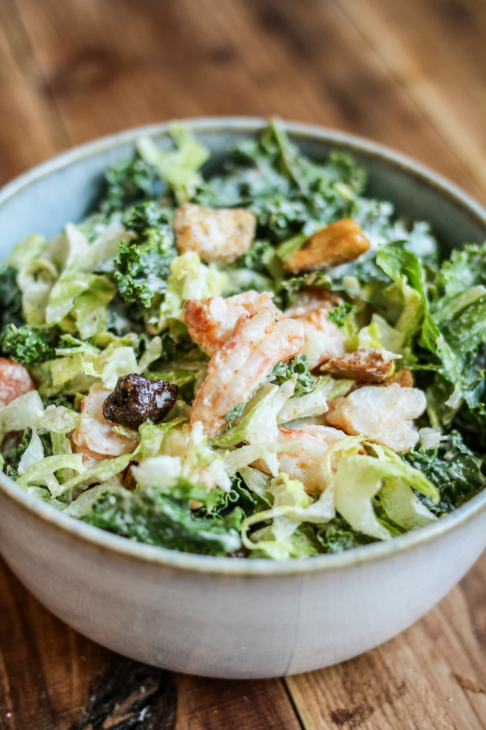 Shrimp Caesar Salad plated in a deep ceramic bowl